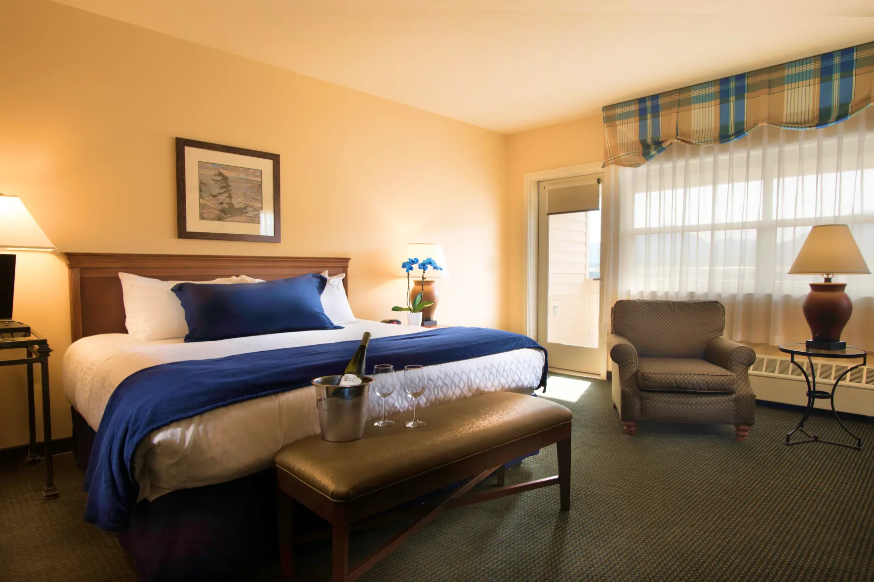Guest room at The Landing Hotel with a king bed, armchair, and window seating